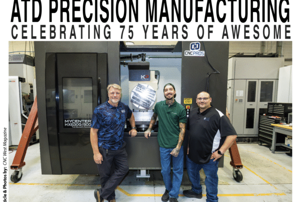 Photo of 3 men in front of CNC mill